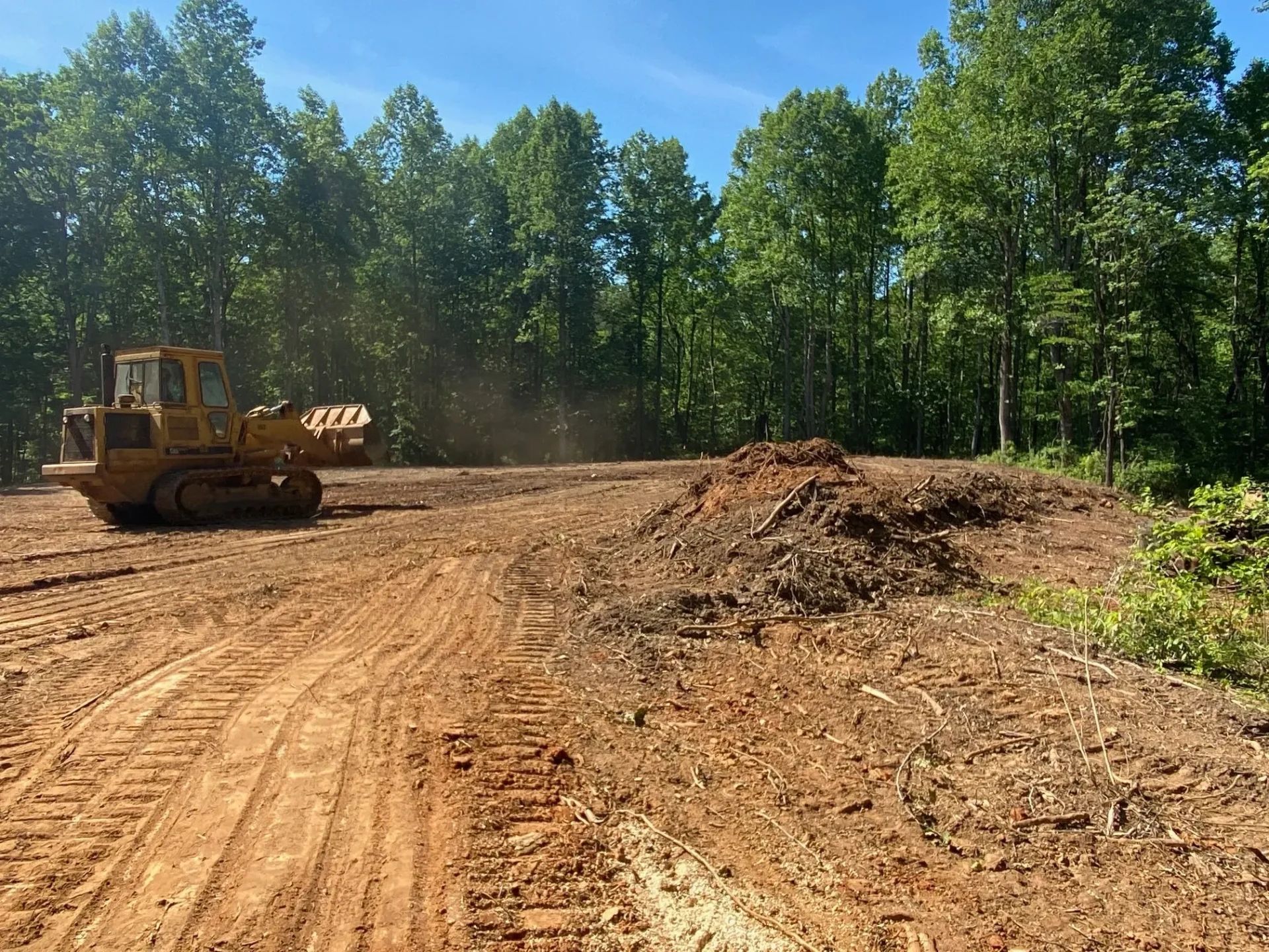 A tractor is parked on the side of a dirt road.